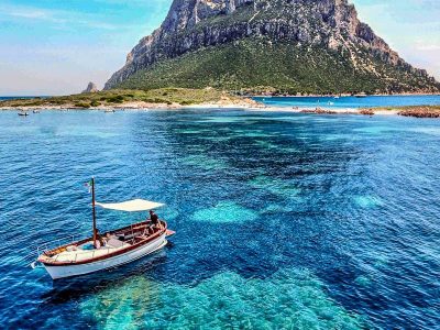 Aerial view of a private boat tour anchored in a bay near Tavolara Island, Sardinia